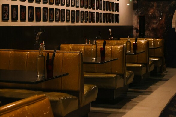 Brown vinyl booth seats sit empty in subdued light in a closed diner